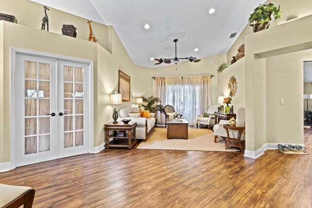 living area featuring high vaulted ceiling, french doors, wood finished floors, and visible vents
