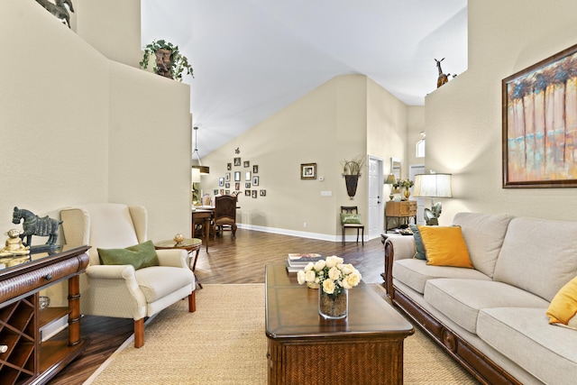 living area featuring high vaulted ceiling, baseboards, and wood finished floors
