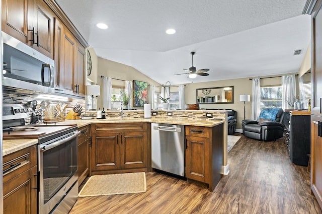 kitchen with ceiling fan, appliances with stainless steel finishes, a peninsula, open floor plan, and visible vents