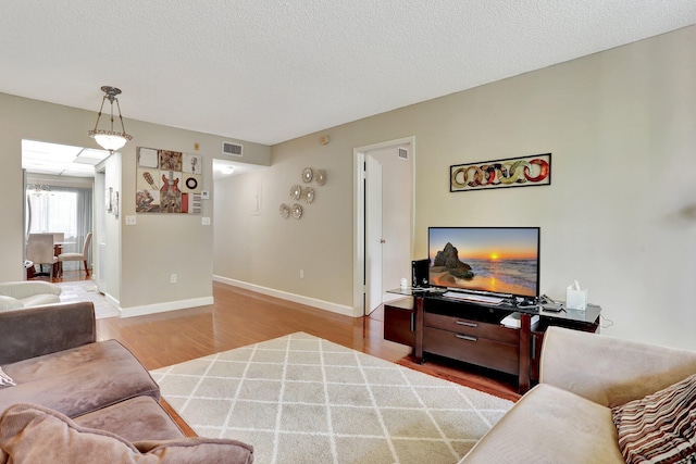 7451 NW 16th St Unit 303, Plantation, FL 33313 - living room with baseboards, wood finished floors, visible vents, and a textured ceiling