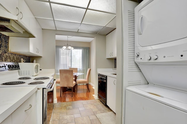 7451 NW 16th St Unit 303, Plantation, FL 33313 - kitchen featuring white cabinets, stacked washer / dryer, light countertops, white electric range oven, and a chandelier