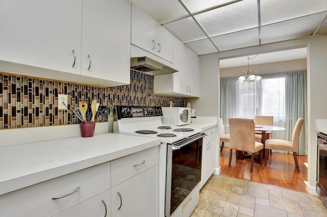 7451 NW 16th St Unit 303, Plantation, FL 33313 - kitchen featuring under cabinet range hood, white appliances, light countertops, backsplash, and a notable chandelier