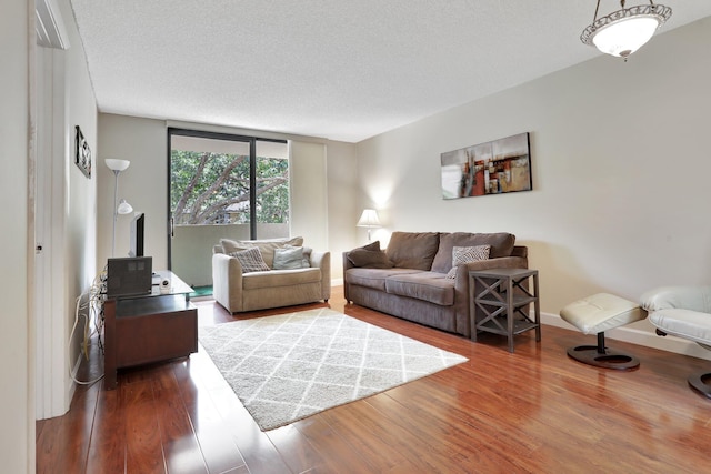 7451 NW 16th St Unit 303, Plantation, FL 33313 - living room featuring baseboards, wood finished floors, and a textured ceiling