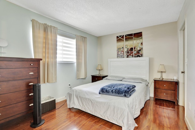 7451 NW 16th St Unit 303, Plantation, FL 33313 - bedroom with baseboards, wood finished floors, and a textured ceiling