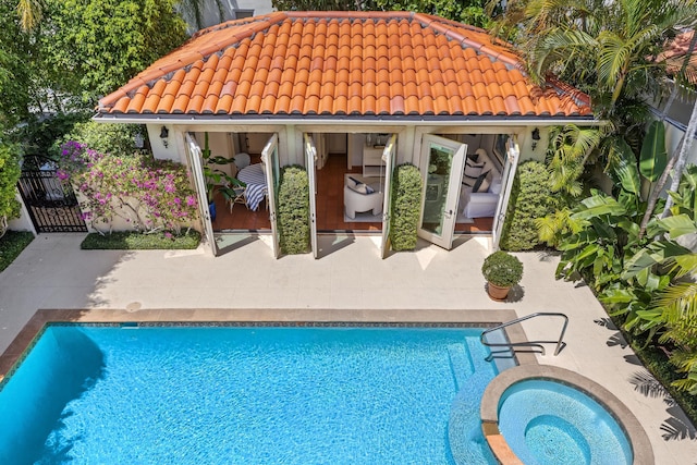 pool featuring a patio and an in ground hot tub