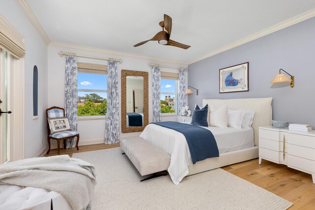 bedroom with wood finished floors, crown molding, and a ceiling fan