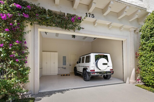 garage with driveway and electric panel