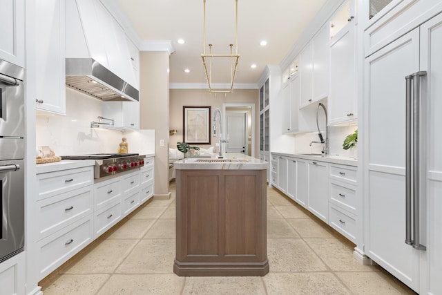 kitchen featuring a sink, glass insert cabinets, appliances with stainless steel finishes, ornamental molding, and a kitchen island