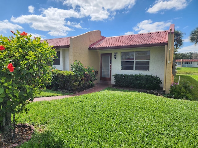 142 Lake Anne Dr, West Palm Beach, FL 33411 - view of front of home with stucco siding, a front lawn, and a tile roof