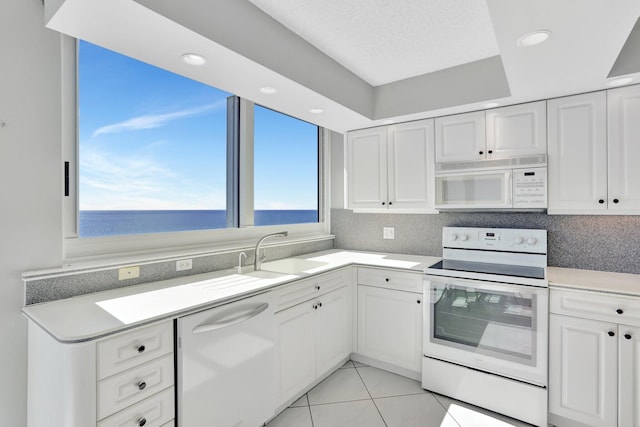 1360 S Ocean Blvd Unit 2508, Pompano Beach, FL 33062 - kitchen with white appliances, light countertops, white cabinets, light tile patterned floors, and recessed lighting
