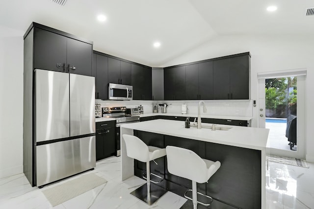 626 33rd St, West Palm Beach, FL 33407 - kitchen featuring appliances with stainless steel finishes, dark cabinets, a sink, tasteful backsplash, and lofted ceiling