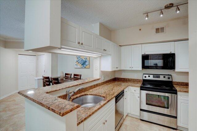 2221 Tuscany Way, Boynton Beach, FL 33435 - kitchen with white cabinets, stainless steel range with electric cooktop, black microwave, and visible vents