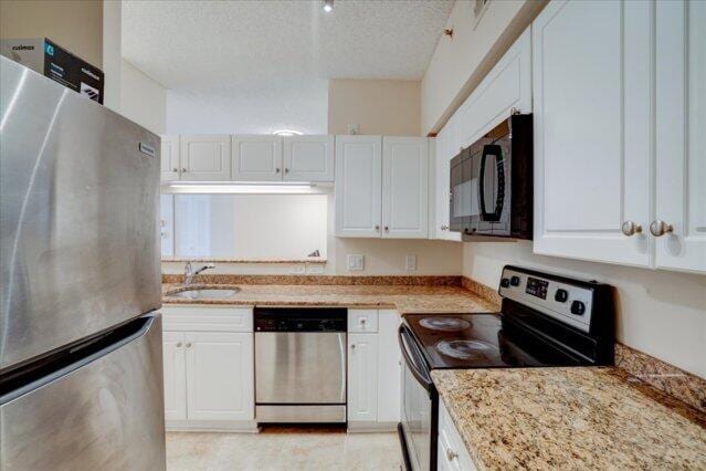 2221 Tuscany Way, Boynton Beach, FL 33435 - bedroom featuring a textured ceiling, light wood finished floors, and baseboards
