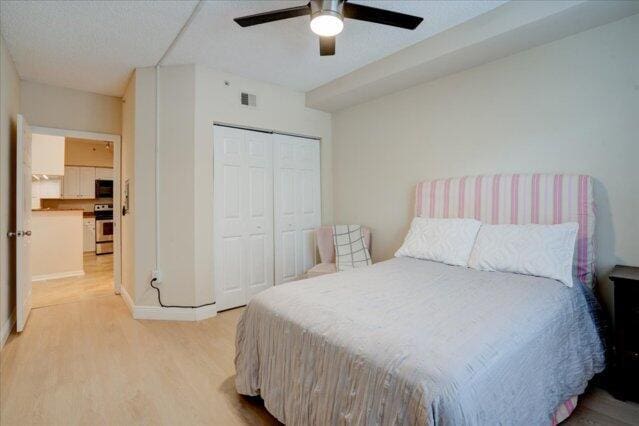 2221 Tuscany Way, Boynton Beach, FL 33435 - bedroom featuring baseboards, a textured ceiling, and light wood-style floors