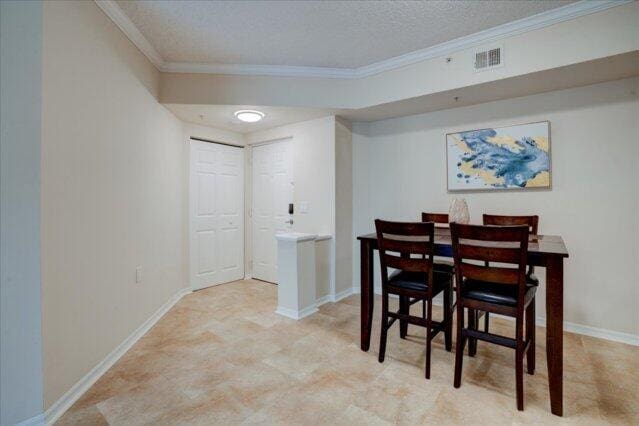 2221 Tuscany Way, Boynton Beach, FL 33435 - dining space featuring a textured ceiling, visible vents, baseboards, and ornamental molding
