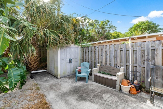 view of patio / terrace featuring a fenced backyard, an outbuilding, and a storage unit