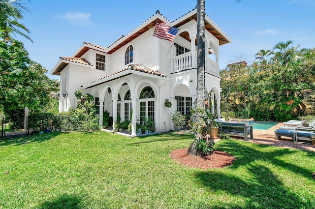 201 Avila Rd, West Palm Beach, FL 33405 - rear view of property featuring a balcony, stucco siding, french doors, and a lawn