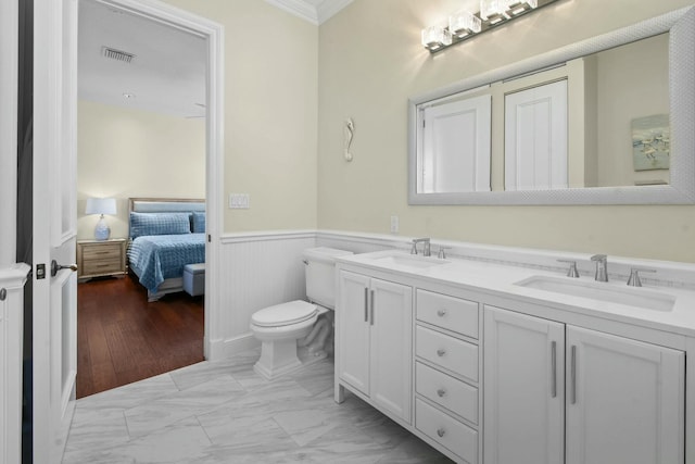 201 Avila Rd, West Palm Beach, FL 33405 - ensuite bathroom with marble finish floors, a wainscoted wall, ornamental molding, double vanity, and toilet