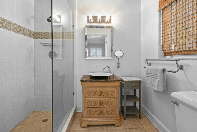 201 Avila Rd, West Palm Beach, FL 33405 - bathroom with tiled shower, toilet, vanity, tile patterned flooring, and baseboards
