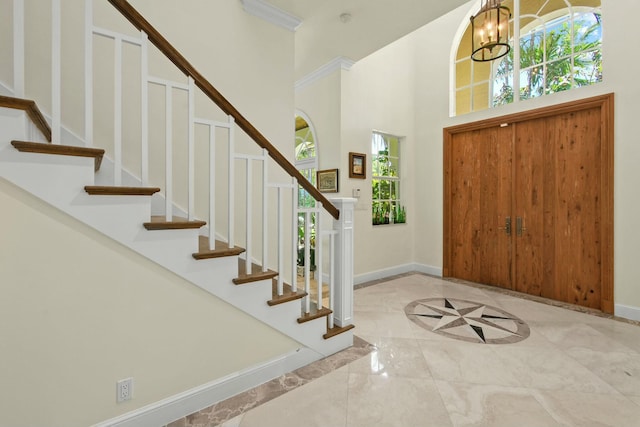 201 Avila Rd, West Palm Beach, FL 33405 - foyer featuring plenty of natural light, baseboards, a towering ceiling, stairway, and a chandelier