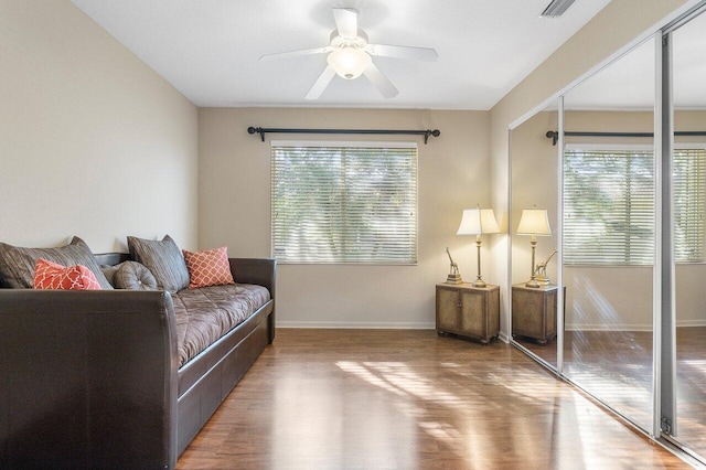 living room featuring ceiling fan, baseboards, wood finished floors, and visible vents