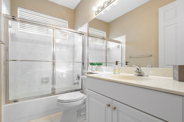 full bath featuring tile patterned flooring, enclosed tub / shower combo, toilet, and vanity