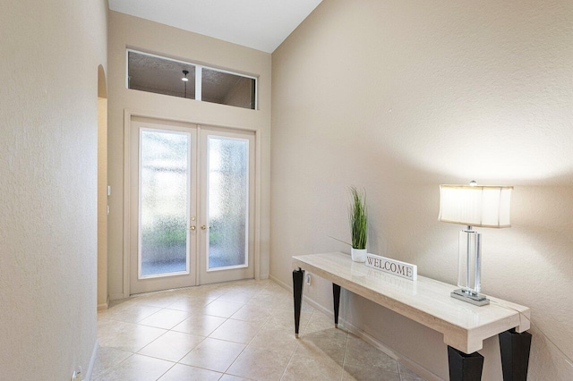 doorway to outside featuring tile patterned flooring, baseboards, and french doors