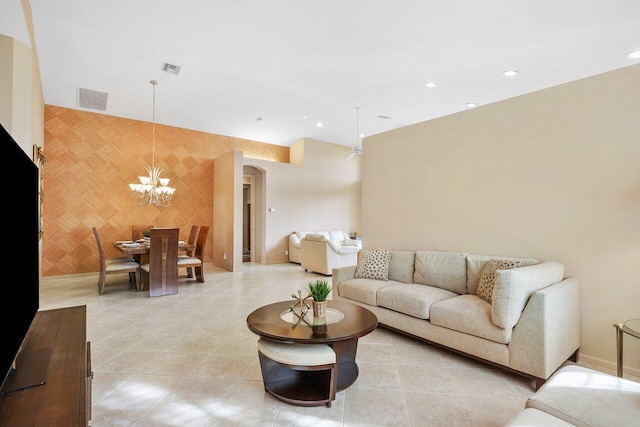 living area featuring baseboards, visible vents, arched walkways, and a chandelier
