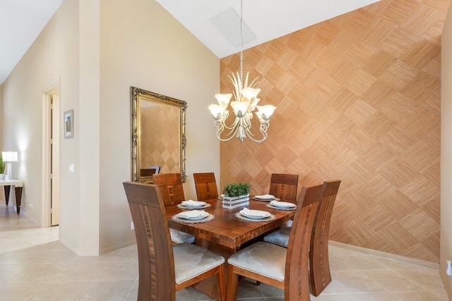 dining area featuring a towering ceiling, baseboards, a chandelier, and light tile patterned floors