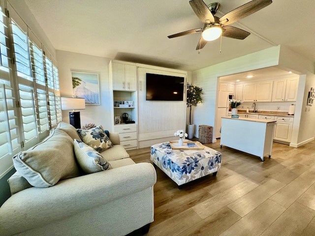 214 Tilford K, Deerfield Beach, FL 33442 - living room featuring light wood-style flooring, baseboards, and a ceiling fan