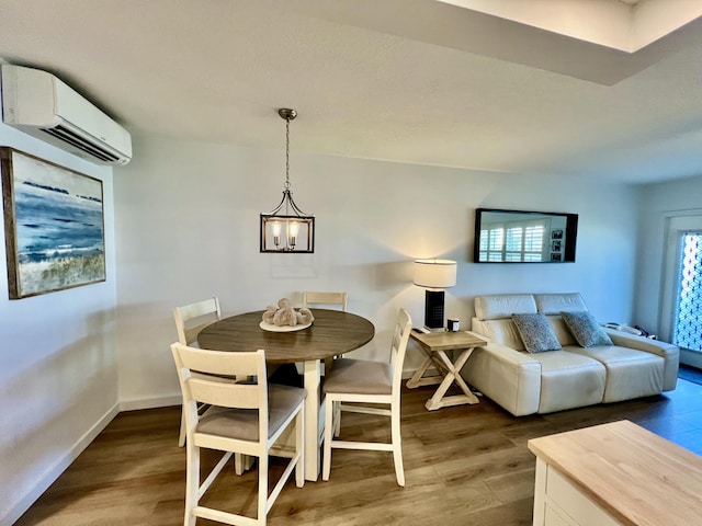 214 Tilford K, Deerfield Beach, FL 33442 - dining space featuring baseboards, a wall mounted AC, an inviting chandelier, and wood finished floors