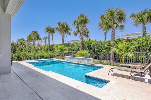 view of swimming pool featuring fence, a patio area, and a pool with connected hot tub