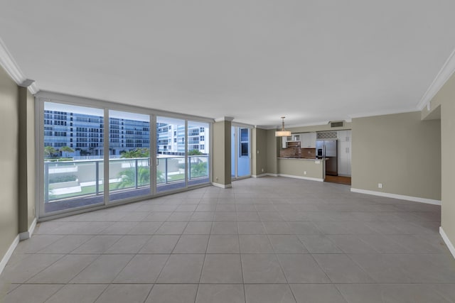 unfurnished living room with ornamental molding, baseboards, and tile patterned flooring