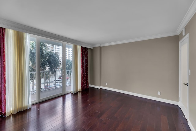 empty room featuring wood finished floors, baseboards, and crown molding