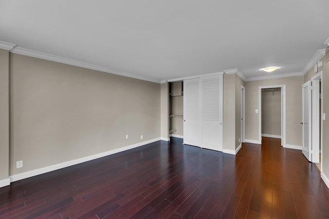 unfurnished bedroom with baseboards, dark wood-style flooring, ornamental molding, and a closet