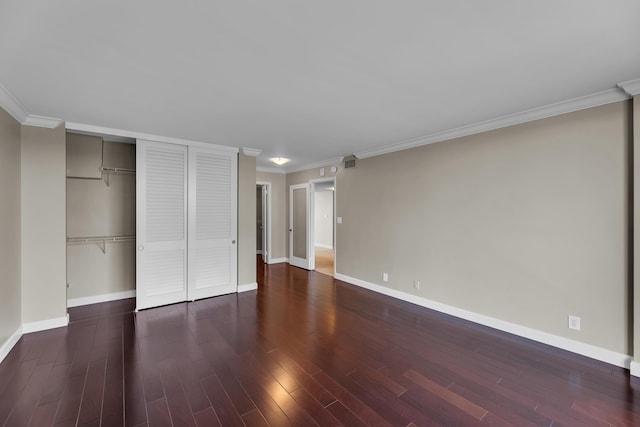 unfurnished bedroom featuring wood finished floors, baseboards, ornamental molding, and a closet