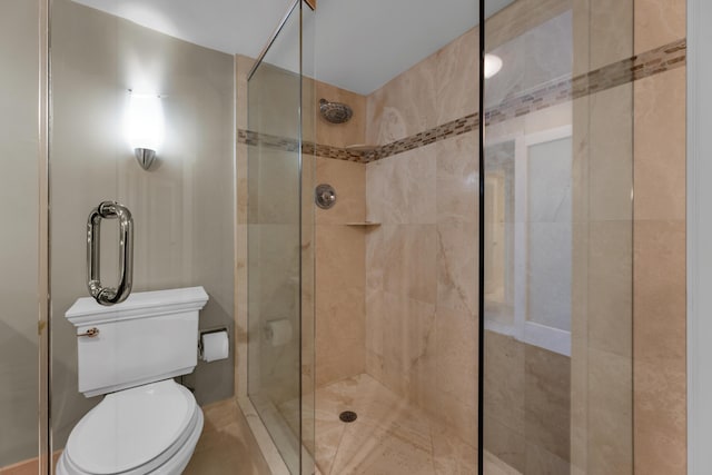 bathroom featuring a stall shower and toilet