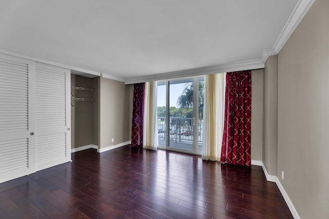 unfurnished bedroom featuring baseboards, access to exterior, ornamental molding, wood finished floors, and a closet