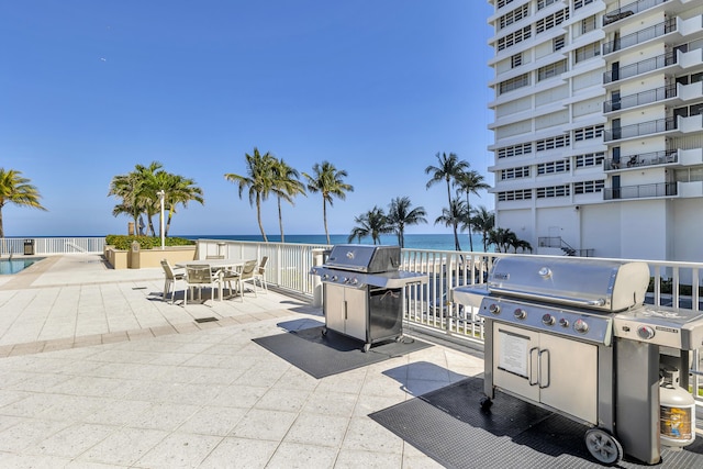 view of patio featuring a grill, outdoor dining area, and a water view