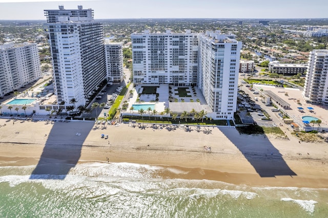 view of urban area featuring a pool area and waterfront with a beach