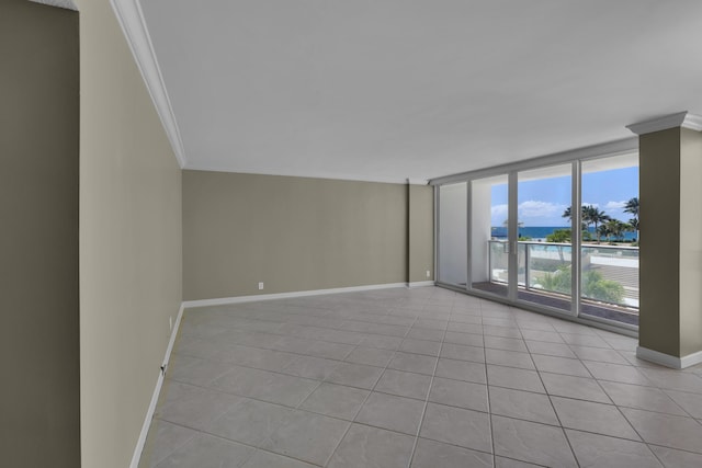 unfurnished room with crown molding, baseboards, light tile patterned floors, and floor to ceiling windows