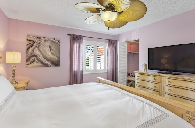 bedroom with a ceiling fan, a textured ceiling, and a closet