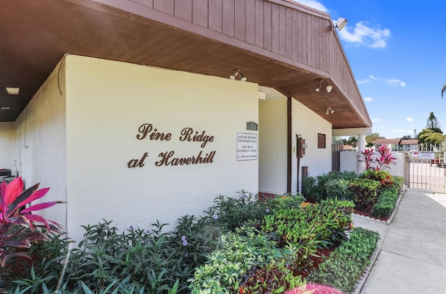 view of exterior entry featuring stucco siding, a gate, and fence