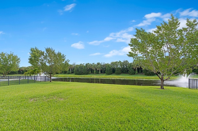 view of yard with fence and a water view