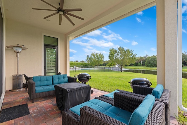 view of patio with a fenced backyard, outdoor lounge area, a water view, and a ceiling fan