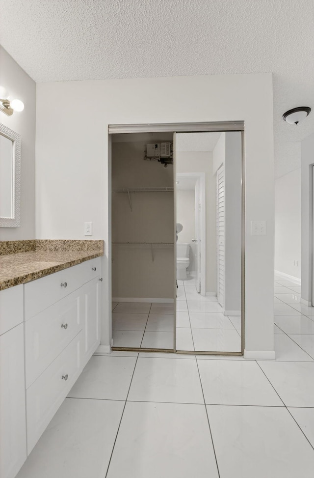 21839 Arriba Real Unit 10-D, Boca Raton, FL 33433 - full bathroom featuring vanity, a textured ceiling, tile patterned floors, and a walk in closet