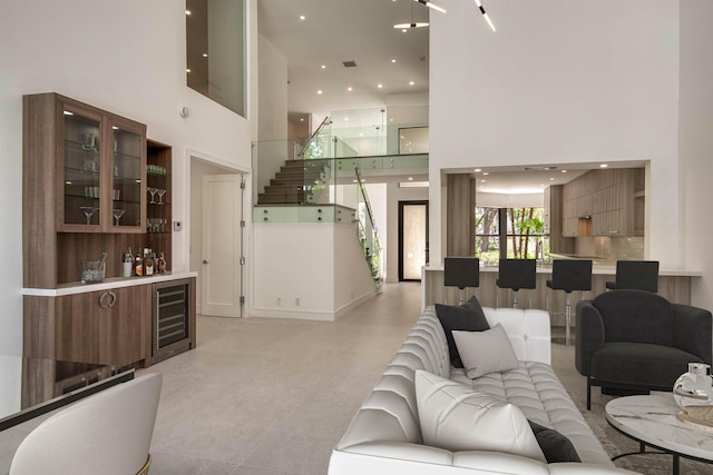 13890 Parc Dr, Palm Beach Gardens, FL 33410 - living area featuring wine cooler, a towering ceiling, a bar, stairs, and recessed lighting