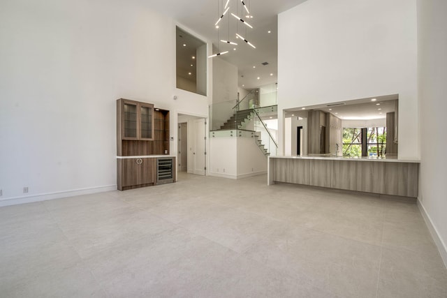 13890 Parc Dr, Palm Beach Gardens, FL 33410 - unfurnished living room featuring a towering ceiling, baseboards, and stairway