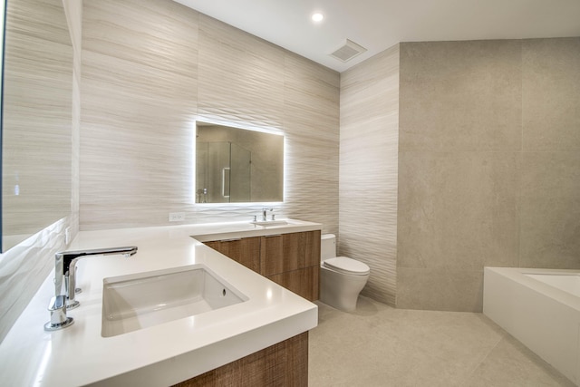 13890 Parc Dr, Palm Beach Gardens, FL 33410 - bathroom featuring tile walls, toilet, tile patterned floors, double vanity, and a bathtub