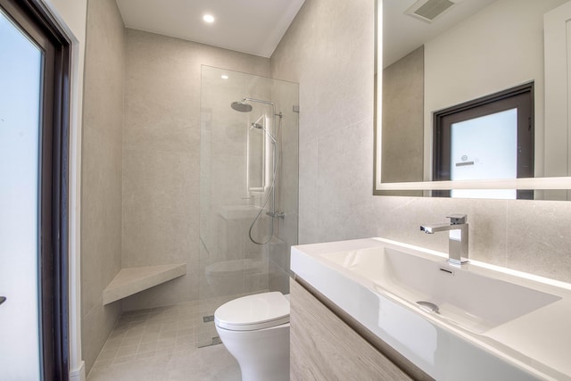 13890 Parc Dr, Palm Beach Gardens, FL 33410 - bathroom with toilet, vanity, a walk in shower, tile walls, and tile patterned flooring